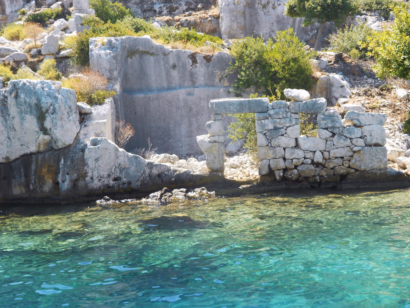 Ruinen der versunkenen Stadt an der Wasserlinie von Kekova mit türkisem Meer